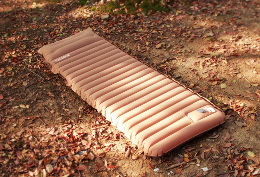 Inflatable camping mattress on a ground covered with leaves